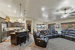 Living area featuring lofted ceiling, ceiling fan, and recessed lighting