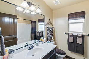 Full bathroom featuring vanity and hanging lights