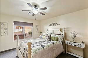 Bedroom with dark colored carpet and a ceiling fan
