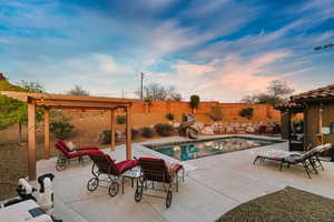 View of swimming pool featuring a pergola, patio surround, a water slide, and a fenced backyard