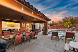 Patio terrace at dusk with outdoor dining area, a patio area, ceiling fan, a fenced backyard, and a pergola