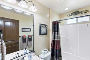 Bathroom with shower / tub combo with curtain and vanity