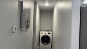 Laundry area featuring washer / dryer and a textured ceiling