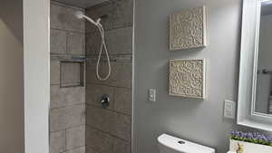 Full bath featuring a shower stall and toilet