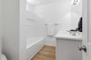 Bathroom featuring vanity, light wood finished floors, and bathtub / shower combination