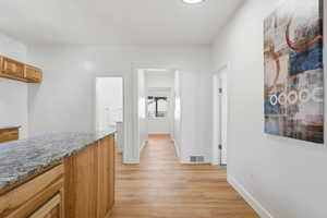 Corridor with light wood-style floors and baseboards