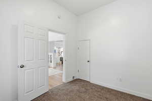 Unfurnished bedroom featuring light carpet and baseboards