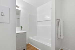 Full bathroom featuring vanity, light wood-type flooring, and  shower combination