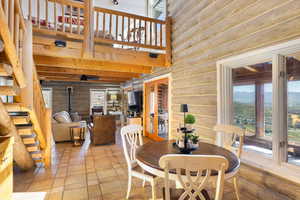 Dining space with a wood stove, a high ceiling, and log walls