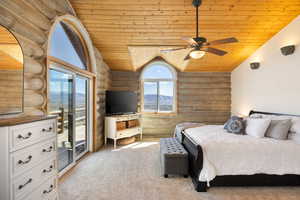 Carpeted bedroom with rustic walls, a vaulted wood ceiling, access to outside, and ceiling fan