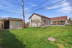 Back of house featuring an outbuilding and a patio