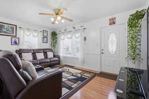 Living room with light wood-style flooring and a ceiling fan