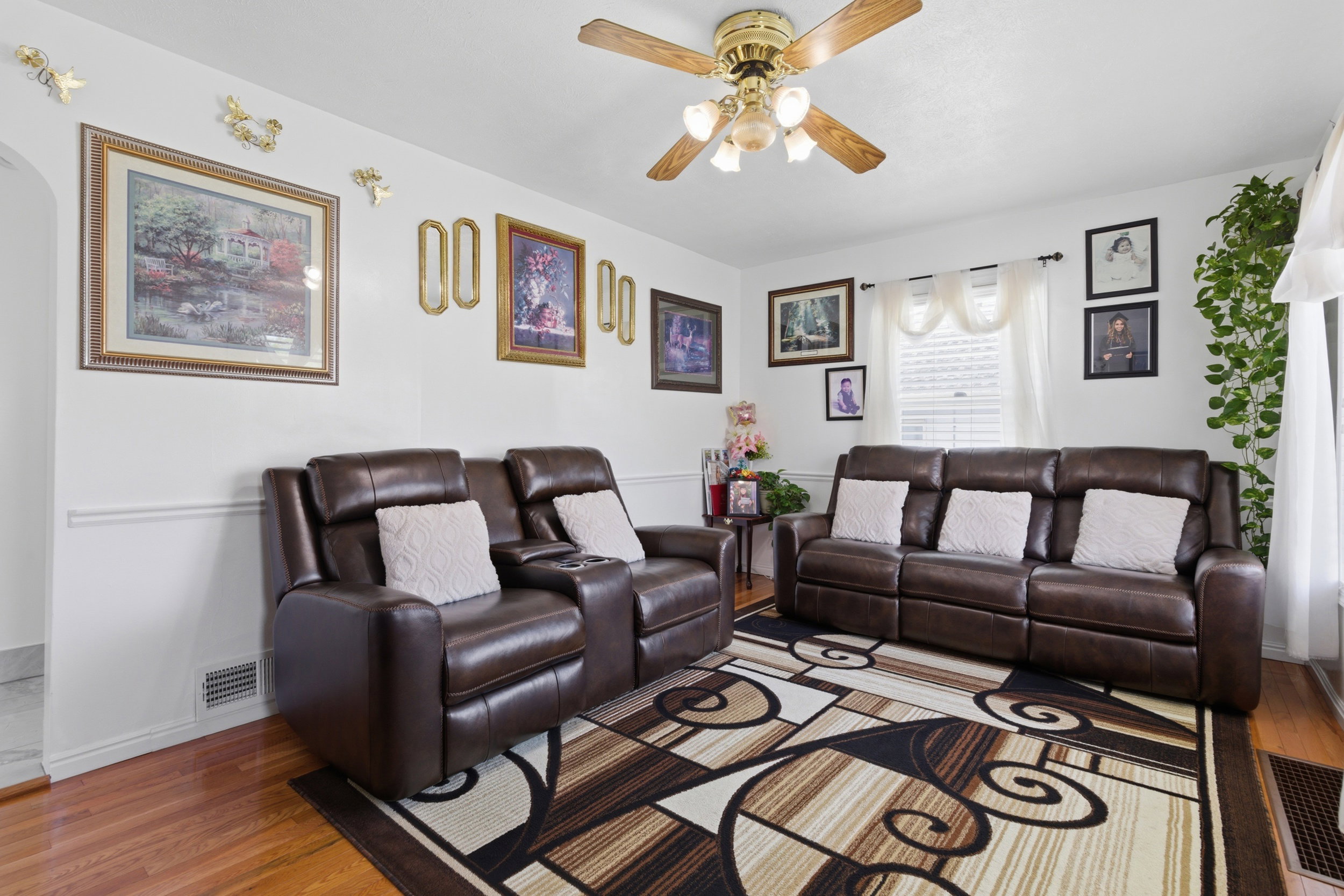 Living room featuring wood-type flooring, a ceiling fan, and arched walkways