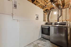 Laundry room with unfinished concrete flooring and washing machine and clothes dryer