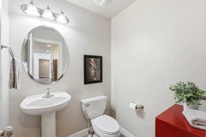 Half bathroom with toilet and baseboards