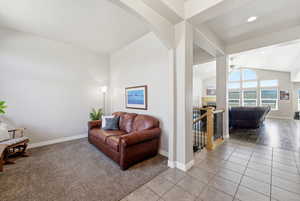 Carpeted living area with a fireplace, lofted ceiling, tile patterned flooring, recessed lighting, and ceiling fan