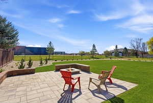 Fenced backyard with a fire pit and a patio area