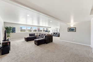 Living area with light carpet and recessed lighting