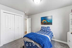 Carpeted bedroom featuring baseboards and a closet