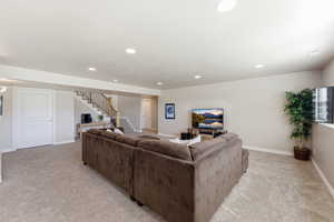Living area with light colored carpet and recessed lighting