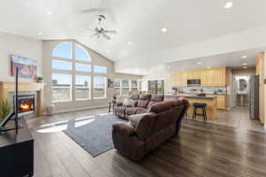 Living area featuring a ceiling fan, a tile fireplace, light wood-type flooring, recessed lighting, and lofted ceiling