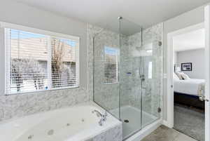 Ensuite bathroom featuring a stall shower, a tub with jets, light colored carpet, and light tile patterned floors