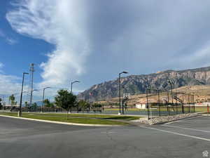 View of asphalt street featuring sidewalks, curbs, and a mountain view