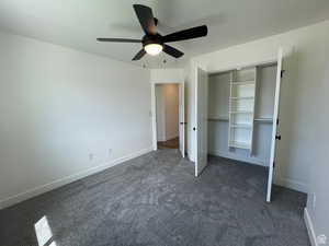Unfurnished bedroom featuring dark carpet, a ceiling fan, and a closet