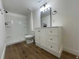 Full bathroom with vanity, a shower stall, dark wood-style floors, and a textured ceiling