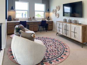 Office space featuring built in study area and light colored carpet