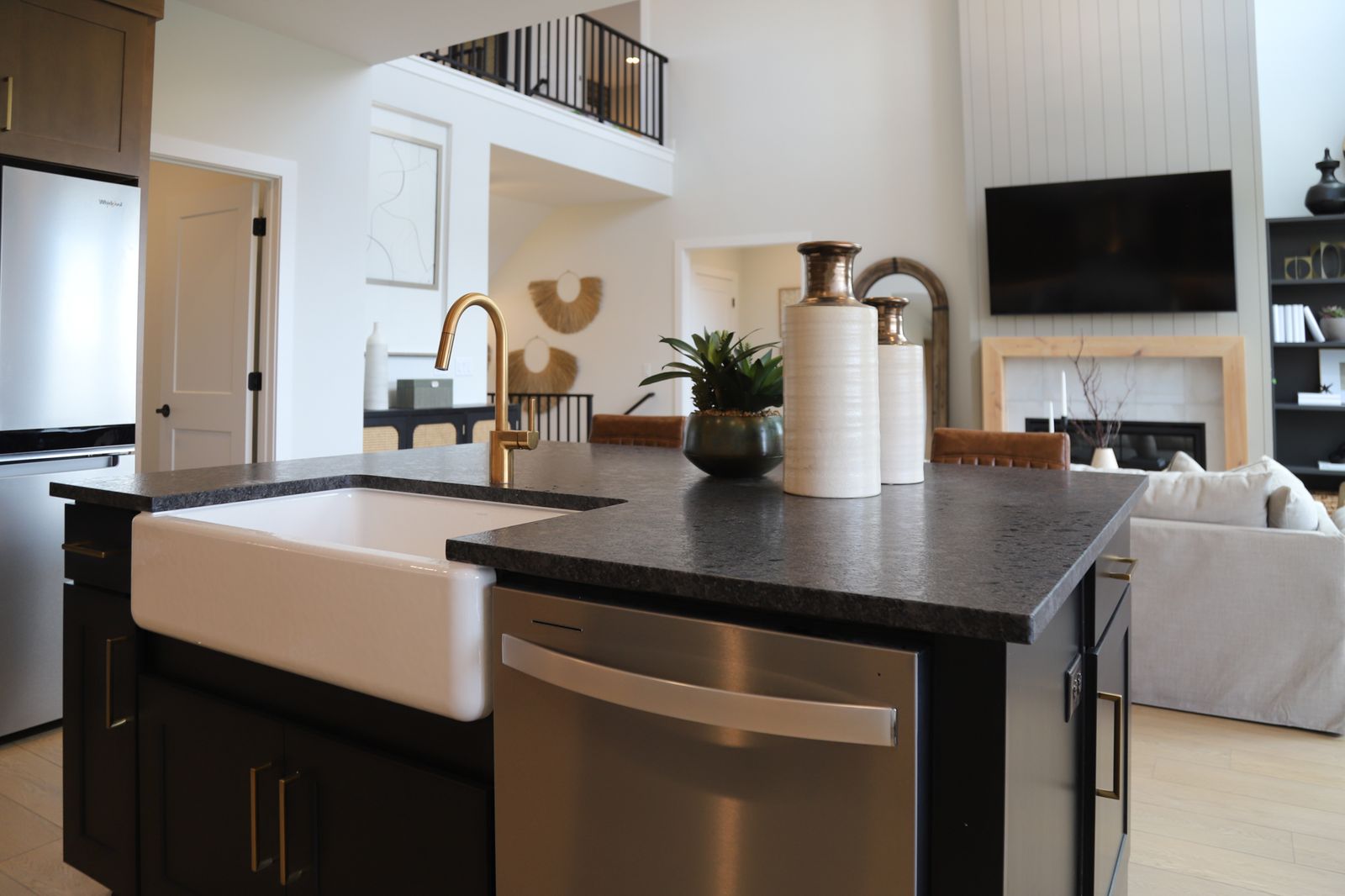 Kitchen with an island with sink, open floor plan, stainless steel appliances, and dark cabinets