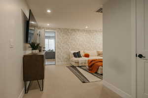 Bedroom with light carpet, recessed lighting, and wallpapered walls