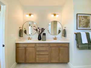 Bathroom featuring double vanity and baseboards