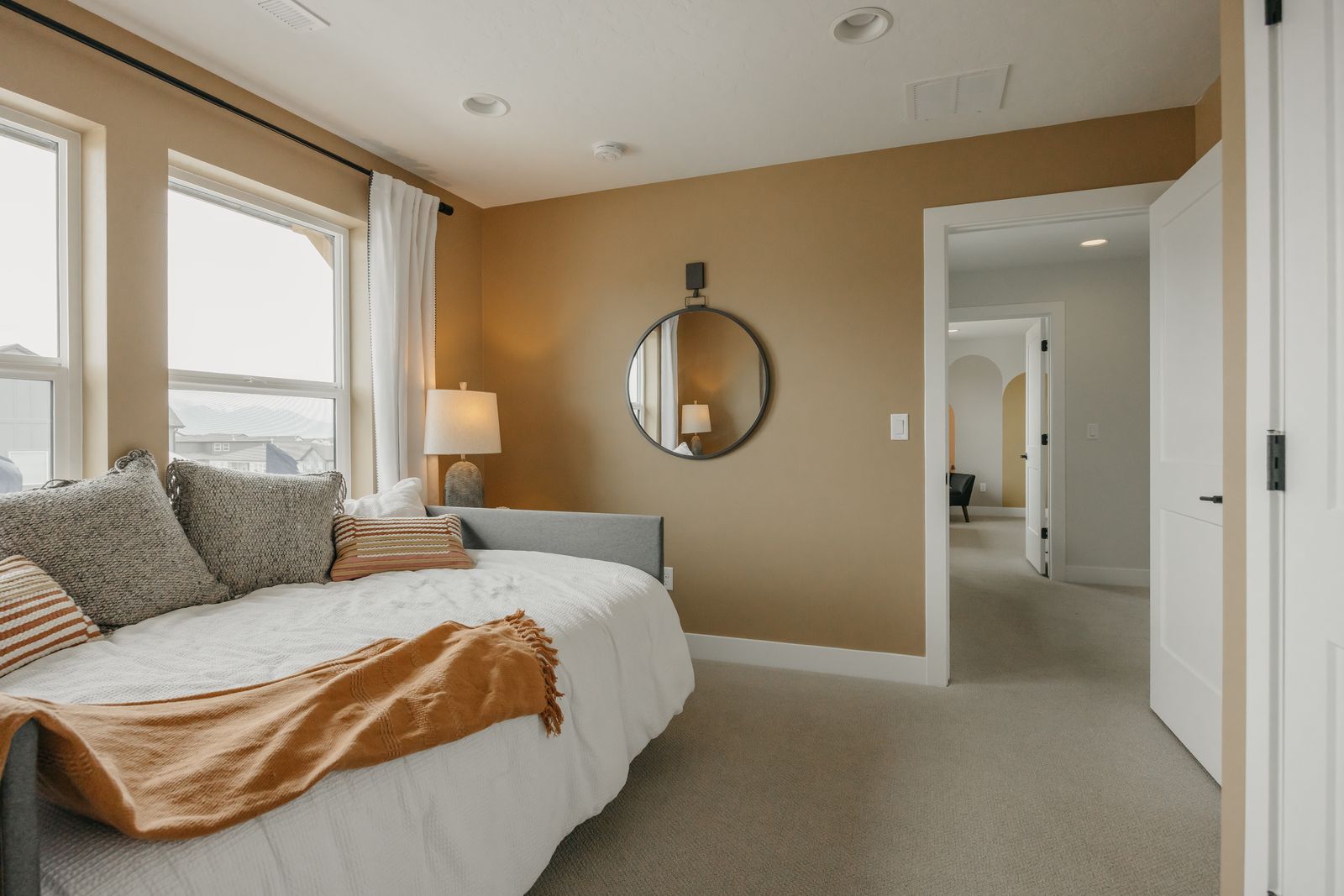 Bedroom with light carpet, arched walkways, and recessed lighting