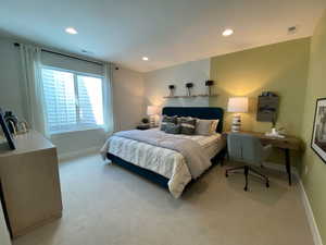 Bedroom with recessed lighting, light colored carpet, and a desk