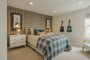 Bedroom with an accent wall, light carpet, wallpapered walls, and recessed lighting