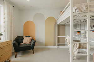 Bedroom featuring light carpet and baseboards