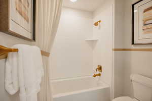 Bathroom featuring shower / bath combo with shower curtain and toilet