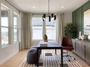 Office space featuring light wood-style floors and hanging lights
