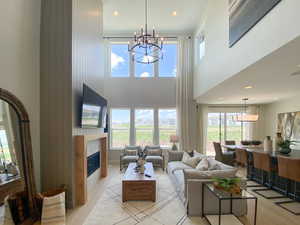 Living room featuring a chandelier, a fireplace, and a high ceiling