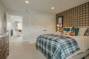 Bedroom featuring wallpapered walls, an accent wall, recessed lighting, a closet, and light carpet
