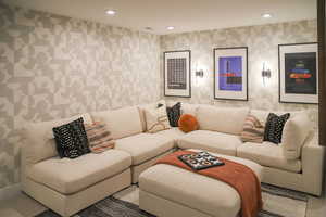 Living room featuring wallpapered walls, carpet floors, and recessed lighting