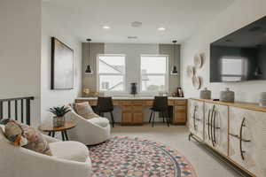 Office space with built in desk, light carpet, and recessed lighting