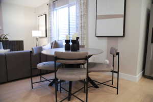 Dining area featuring light wood-type flooring and baseboards