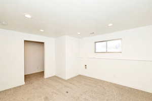 Empty room featuring light carpet and recessed lighting
