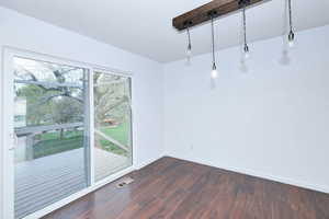 Spare room with a textured ceiling and dark wood-type flooring