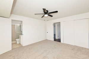Unfurnished bedroom with a textured ceiling, carpet, ensuite bath, ceiling fan, and a closet