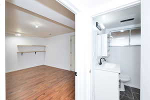 Half bathroom featuring vanity and dark wood finished floors