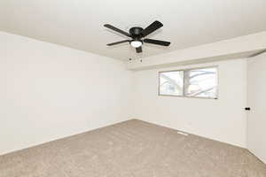 Carpeted empty room featuring a textured ceiling and a ceiling fan