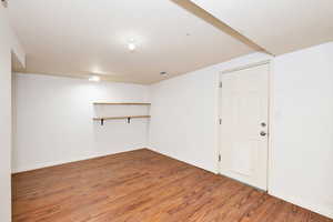 Finished basement with wood finished floors and baseboards